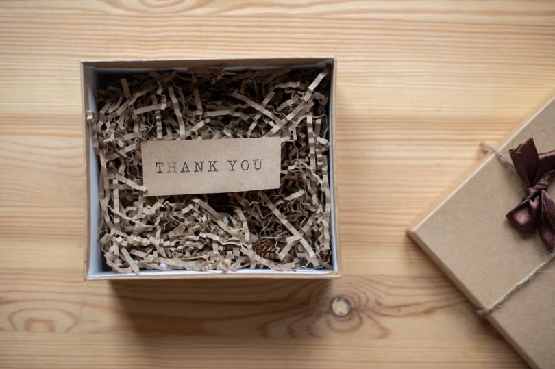 box with shredded paper inside and a thank you note